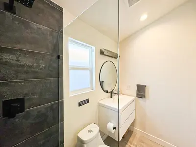 a bathroom with a toilet and a mirror at Charming Poolside ADU Near SoFi Stadium - MK3LAD in Los Angeles