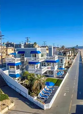 a large white house with blue balconies and chairs at 90210 Beach House Top Unit in Hermosa Beach