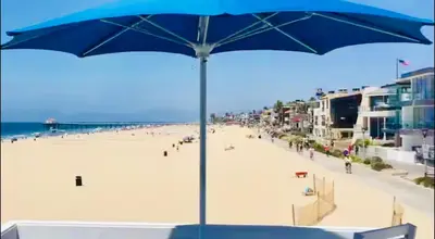 a blue umbrella sitting on top of a beach at 90210 Beach House Top Unit in Hermosa Beach
