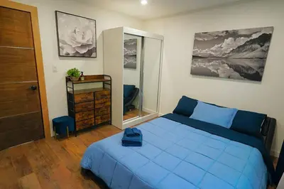 a bedroom with a blue bed and a mirror at Beautiful Renovated Cozy Forest Home with Hot Tub in Crestline in Crestline