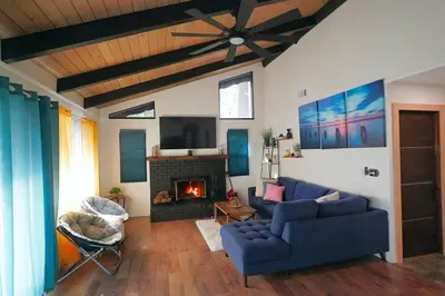 a living room with a blue couch and a fireplace at Beautiful Renovated Cozy Forest Home with Hot Tub in Crestline in Crestline