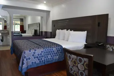 a hotel room with a large bed and a table at Galaxy Inn in Los Angeles