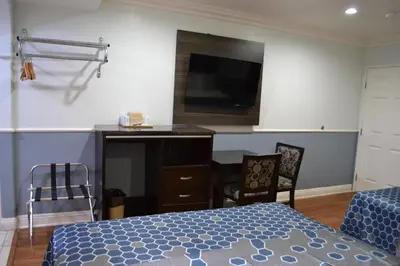 a bedroom with a bed and a desk and a tv at Galaxy Inn in Los Angeles