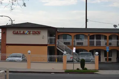 a calgary inn with cars parked in the parking lot at Galaxy Inn in Los Angeles