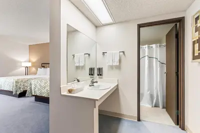 a bathroom with a sink and a bed at HomeTowne Studios by Red Roof Ridgecrest in Ridgecrest