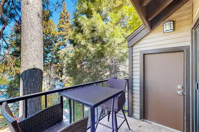 a patio with a table and chairs on a balcony at Lake Arrowhead Views! Condo with Shared Pool and Spa in Lake Arrowhead