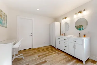 a white bathroom with a sink and a mirror at Lake Arrowhead Views! Condo with Shared Pool and Spa in Lake Arrowhead