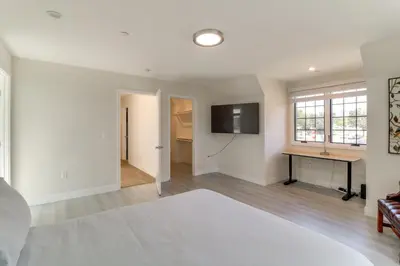 a room with a bed and a desk and a television at 1 Mi to Dtwn Pasadena! Newly Built Home in Pasadena