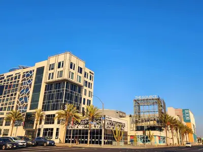 a tall building with palm trees in front of a street at Charming Bedroom Near Disney Land, Orange County in La Palma