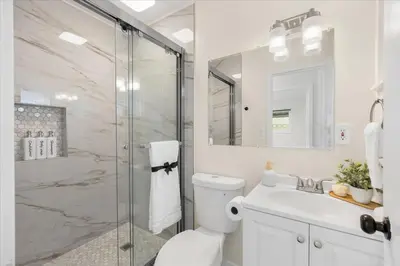 a bathroom with a shower and a toilet and a sink at Luxurious Newly Remodeled 4 Bedroom Home with Large Backyard near Disneyland in Anaheim