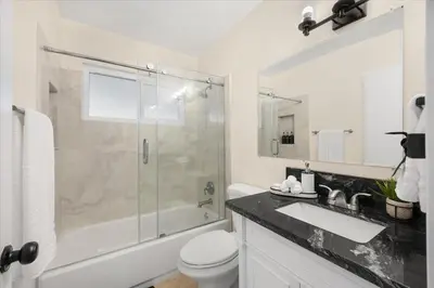 a bathroom with a shower and a toilet and a sink at Luxurious Newly Remodeled 4 Bedroom Home with Large Backyard near Disneyland in Anaheim
