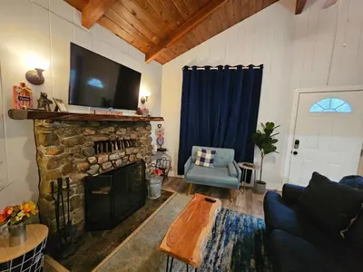 a living room with a fireplace with a tv on top at Forest Moon Cottage in Big Bear City Airport