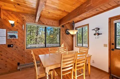 a dining room with a table and chairs at The Mountain Treehouse, Jacuzzi Large Backyard! in Big Bear Lake
