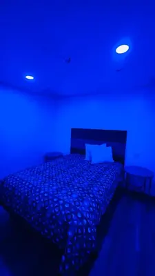a bedroom with a bed with a blue light at vogue motel in South Gate