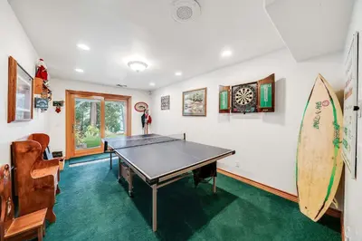 a ping pong table in a room with a surfboard at Navigate Stays Best Dressed Lakefront Home in Lake Arrowhead