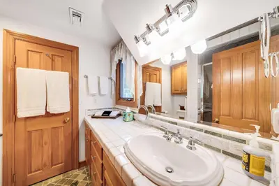 a bathroom with a sink and a mirror at Navigate Stays Best Dressed Lakefront Home in Lake Arrowhead