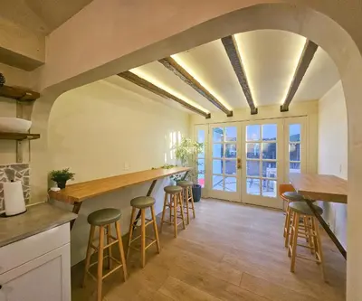 a kitchen with a bar and stools in a room at Brimfield Stay in Los Angeles