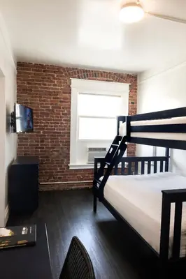 a bedroom with a bunk bed and a brick wall at American Hotel in Los Angeles