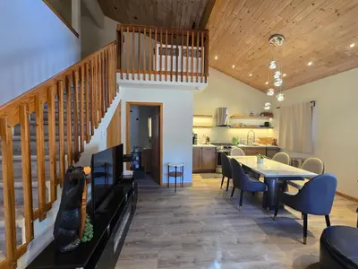 a dining room with a staircase and a table and chairs at Modern Lagunita Cabin Near the Lake in Big Bear Lake