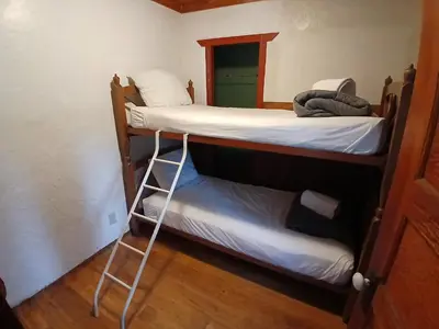 two bunk beds in a room with a small bed at Cabin 33, 3 bedroom 2 bath in Big Bear Lake