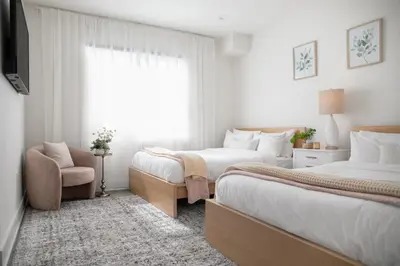 a bedroom with two beds and a chair and a window at 5 Star Private House 5 rooms in Los Angeles