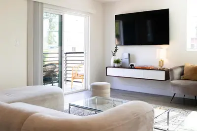 a living room with a couch and a tv on a wall at 5 Star Private House 5 rooms in Los Angeles