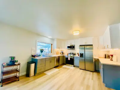 a large kitchen with stainless steel appliances and wooden floors at Cheerful 4 bed, 2 bath with pool near Disneyland in Placentia