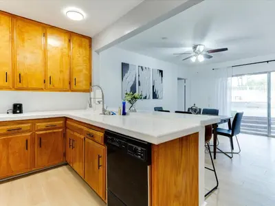 a kitchen with wooden cabinets and a black dishwasher at Modern 4 bedroom in San Fernando in San Fernando