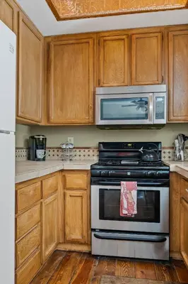 a kitchen with wooden cabinets and a stove and microwave at BIg Bear G5 Getaway in Big Bear Lake