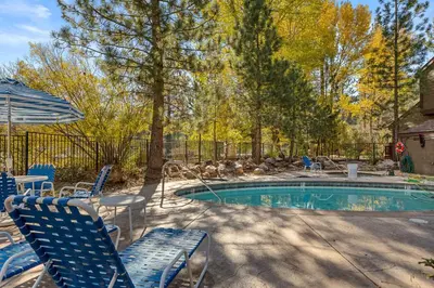 a swimming pool with chairs and an umbrella at BIg Bear G5 Getaway in Big Bear Lake