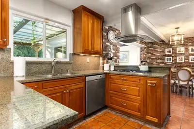 a kitchen with wooden cabinets and a sink at Adorable 4 bedroom home with Pool & more in Los Angeles