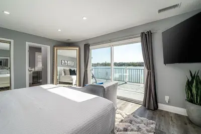 a bedroom with a large bed and a balcony at The Lakefront Oasis in Victorville