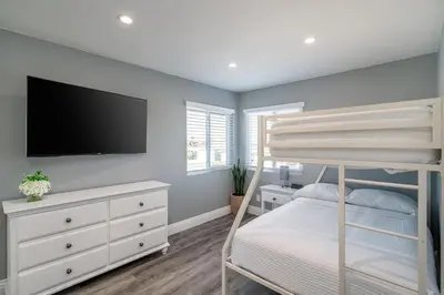 a bedroom with a bunk bed and a flat screen tv at The Lakefront Oasis in Victorville