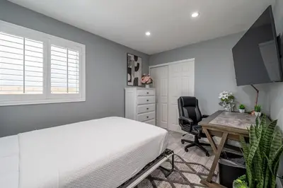 a bedroom with a bed and a desk and a window at The Lakefront Oasis in Victorville
