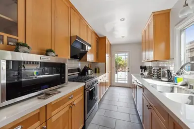a kitchen with wooden cabinets and stainless steel appliances at Cosy 3BD by Santa Monica - Beach & Airport 10 min away in Los Angeles