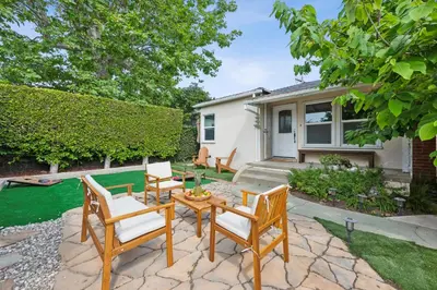 a patio with a table and chairs and a house at Cosy 3BD by Santa Monica - Beach & Airport 10 min away in Los Angeles