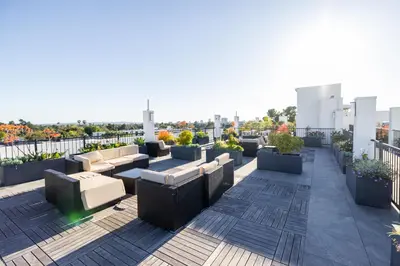 a rooftop patio with couches and plants on a building at Exquisite Haven with Patio Sleeps 4 in Los Angeles