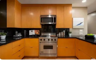 a kitchen with wooden cabinets and a stainless steel oven at Secluded Luxury Hollywood Hills Retreat in Los Angeles