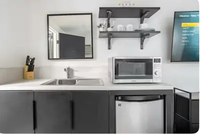 a kitchen counter with a microwave and a sink at Charming one bed one bath privet studio in Tarzana