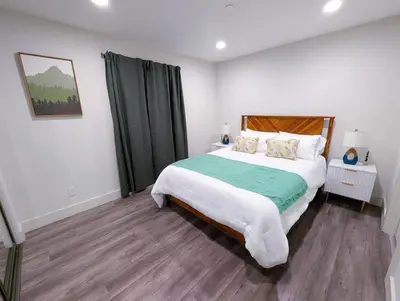 a bedroom with a large bed with a green blanket at Central North Hollywood Home in Los Angeles