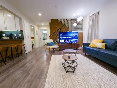 a living room with a blue couch and a tv at Central North Hollywood Home in Los Angeles