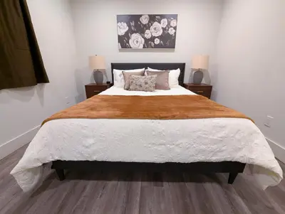 a bedroom with a large bed with two lamps at Central North Hollywood Home in Los Angeles