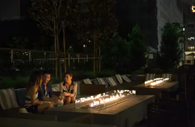 two people sitting on a bench with lit candles at Level Los Angeles - Downtown South Olive in Los Angeles