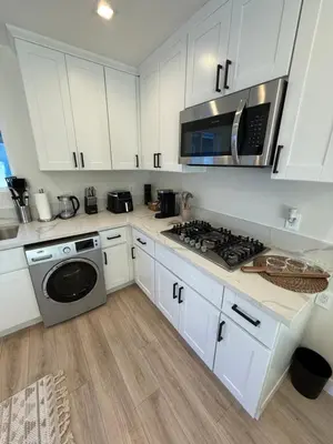 a kitchen with white cabinets and a microwave at Cute House in West Valley Area Heliport