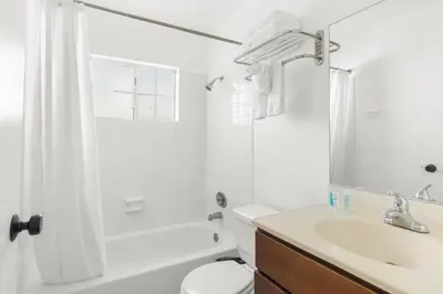 a white bathroom with a toilet and a sink at Modern Furnished 2 Bedroom in West LA in Los Angeles
