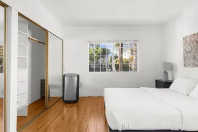 a white bedroom with a bed and a mirror at Modern Furnished 2 Bedroom in West LA in Los Angeles