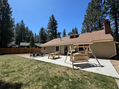 a backyard with a playground and a house at Eagle Point Retreat - Sleeps 13 - 12 Adults Max, Game Room, Foosball, Fireplace, Deck, Barbecue in Big Bear Lake