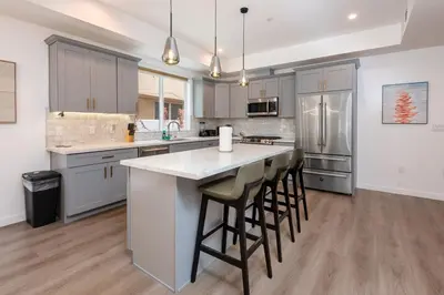 a kitchen with a large island with bar stools at Stunning 3-BR Residence with Free Parking & Patio in Los Angeles