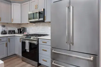 a kitchen with white cabinets and stainless steel appliances at Stunning 3-BR Residence with Free Parking & Patio in Los Angeles