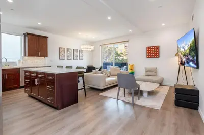 a kitchen and living room with a couch and a table at Luxury 2BR Stay Balcony Views and Free Parking in Los Angeles